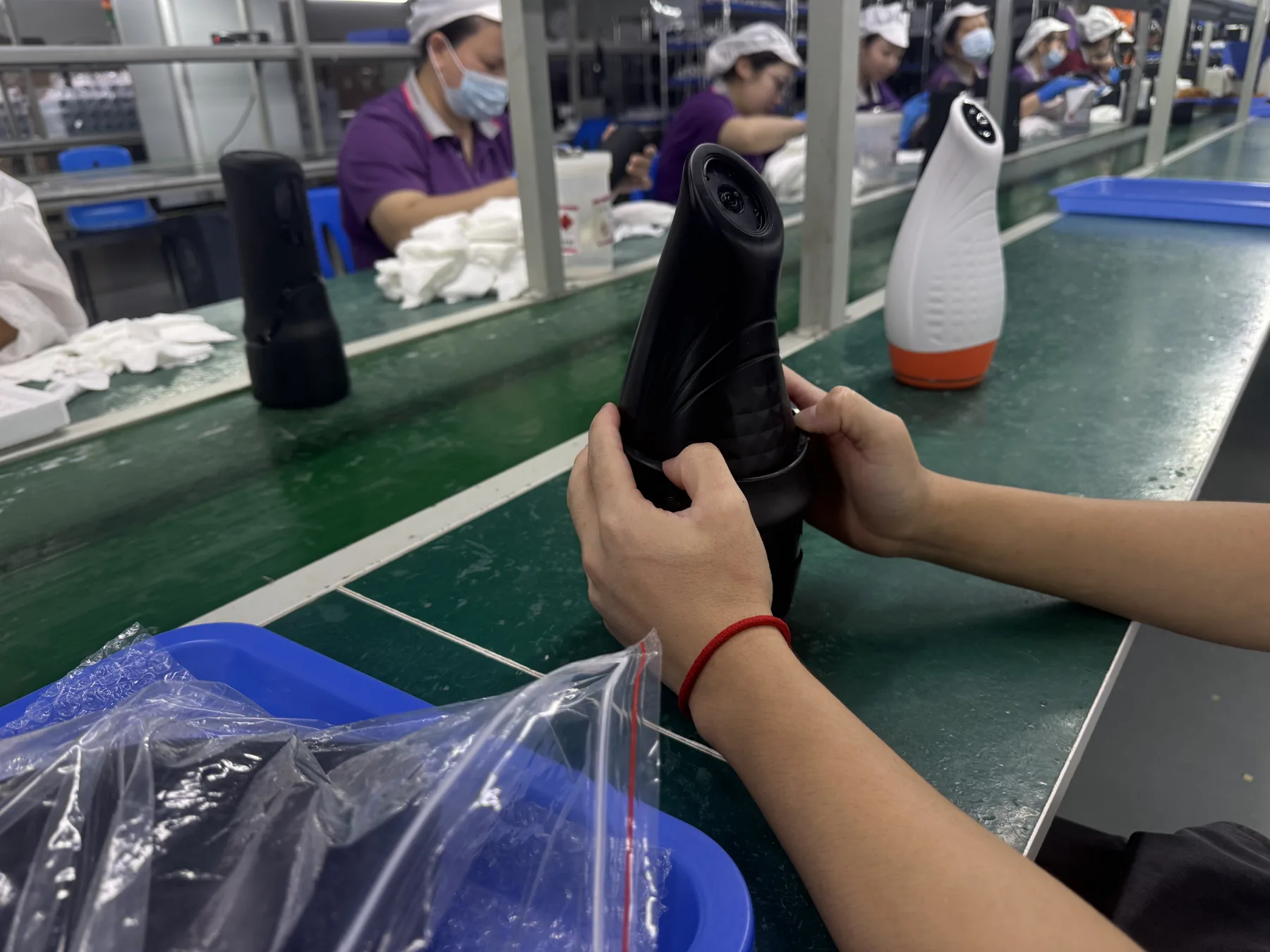 Workers assembling Pulsar devices along a production line